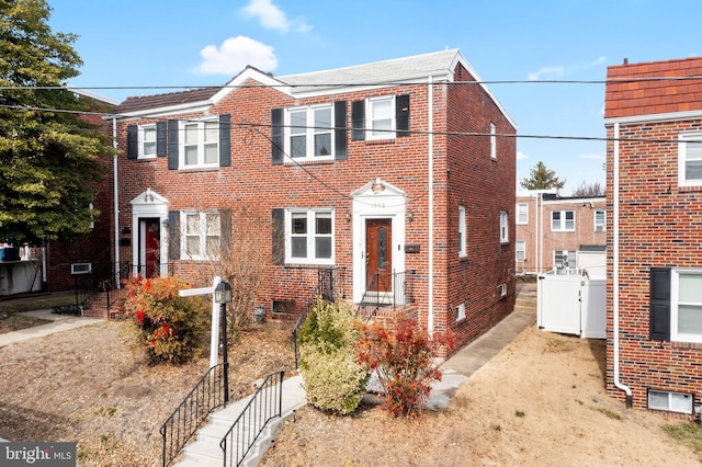 view of front of house featuring fence and brick siding