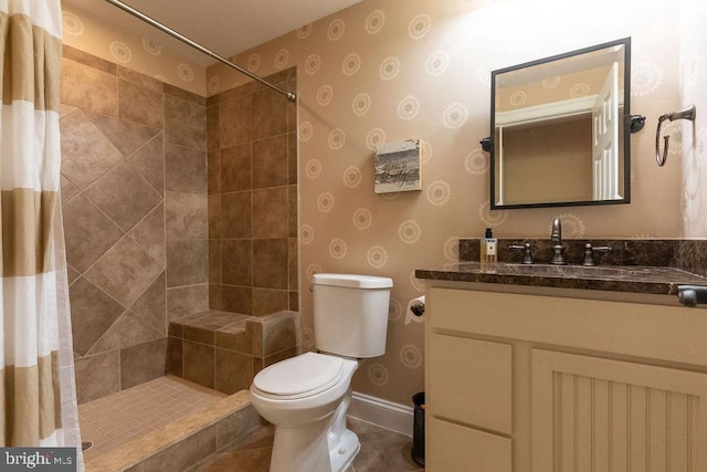 full bathroom featuring baseboards, tiled shower, vanity, and toilet