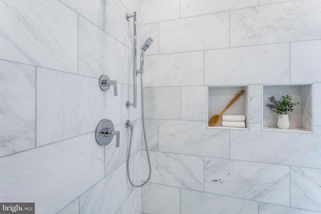 interior details featuring tiled shower