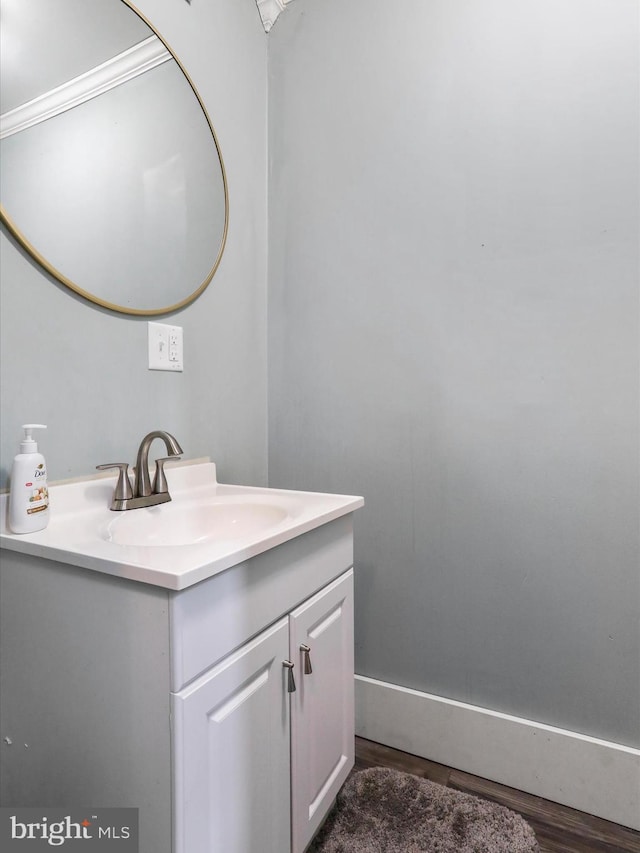 bathroom featuring vanity, baseboards, and wood finished floors