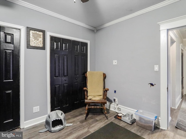 sitting room featuring crown molding, baseboards, and wood finished floors