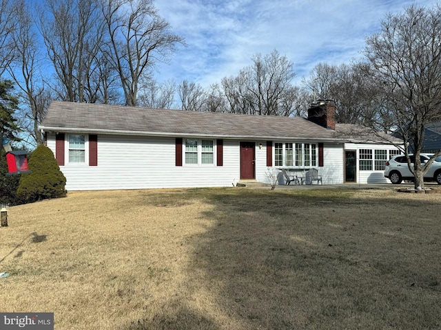 single story home with a chimney and a front yard