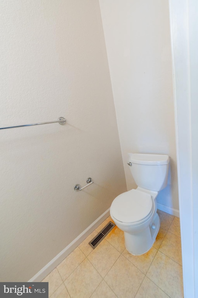 bathroom with baseboards, visible vents, toilet, and tile patterned floors