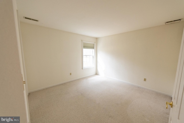 empty room featuring carpet, visible vents, and baseboards