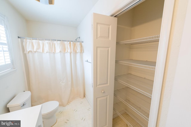 bathroom featuring a shower with shower curtain, vanity, and toilet