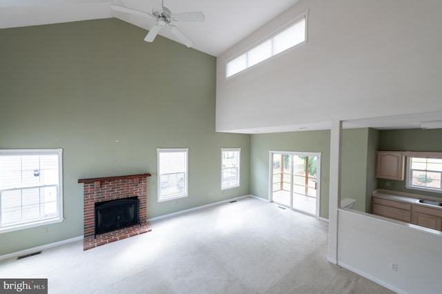 unfurnished living room featuring light carpet, visible vents, baseboards, a fireplace, and high vaulted ceiling