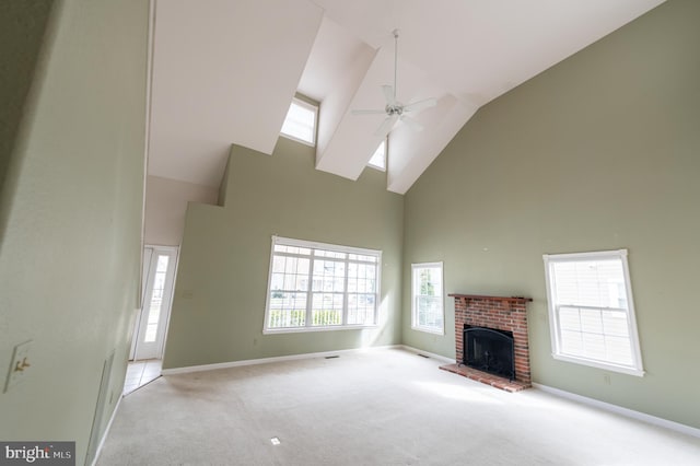 unfurnished living room with baseboards, a fireplace, a ceiling fan, and carpet flooring