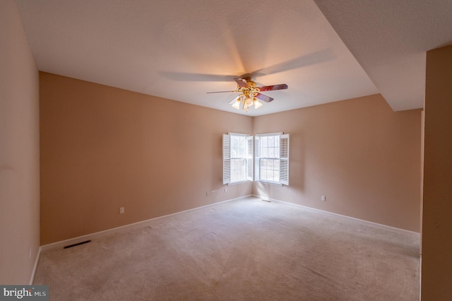 spare room featuring ceiling fan, carpet floors, visible vents, and baseboards