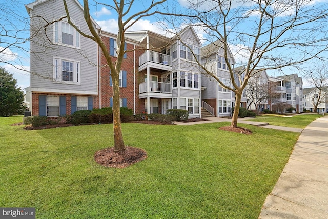 view of front facade featuring brick siding and a front yard