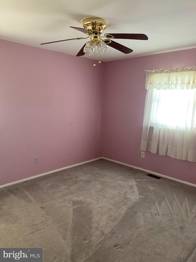 unfurnished room featuring carpet, visible vents, and baseboards