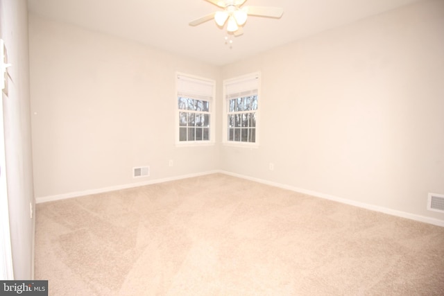 spare room with a ceiling fan, carpet, and baseboards