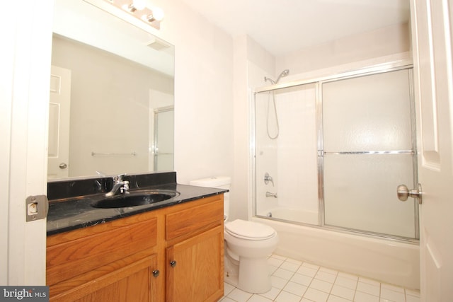 bathroom featuring combined bath / shower with glass door, vanity, toilet, and tile patterned floors