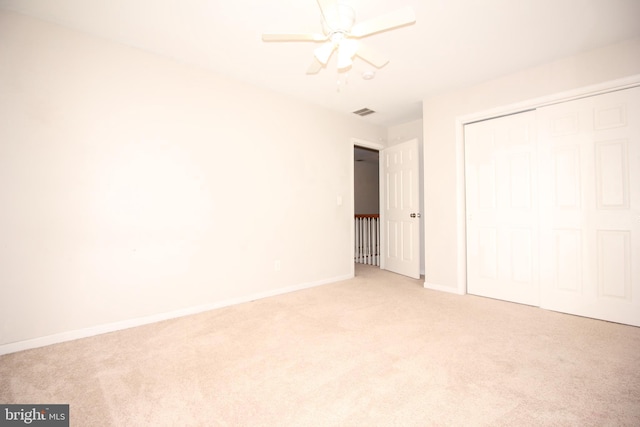 unfurnished bedroom featuring a closet, visible vents, a ceiling fan, light carpet, and baseboards