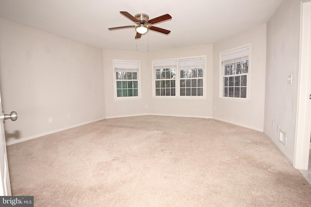 empty room with a wealth of natural light, ceiling fan, baseboards, and carpet flooring