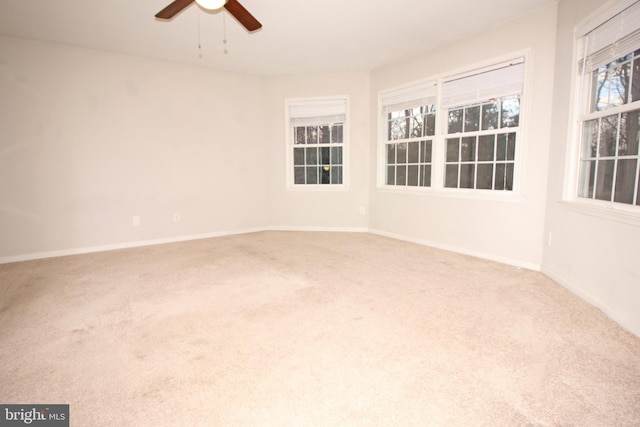 carpeted empty room featuring ceiling fan and baseboards