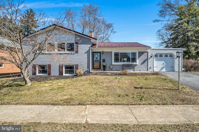 split level home with a standing seam roof, a front lawn, a garage, aphalt driveway, and brick siding