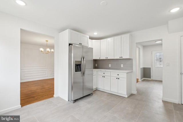 kitchen featuring recessed lighting, white cabinets, light countertops, backsplash, and stainless steel fridge