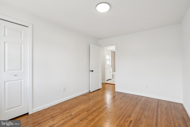 unfurnished room with light wood finished floors and baseboards