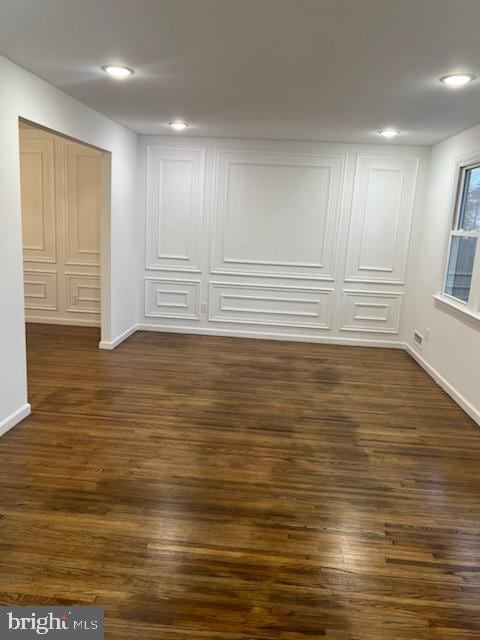 basement with recessed lighting, dark wood-style flooring, and baseboards