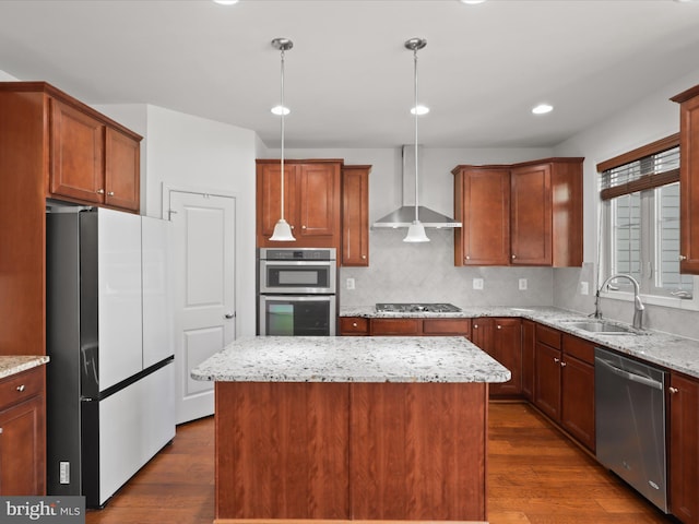 kitchen with wall chimney range hood, dark wood finished floors, stainless steel appliances, and a sink