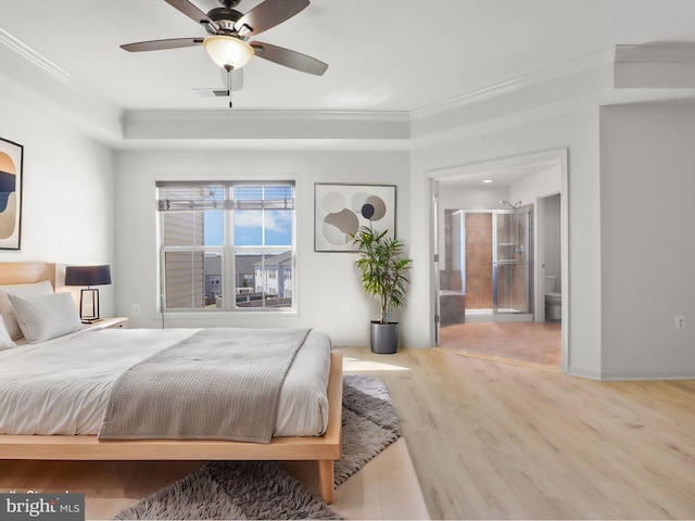 bedroom featuring ensuite bathroom, ceiling fan, wood finished floors, visible vents, and ornamental molding