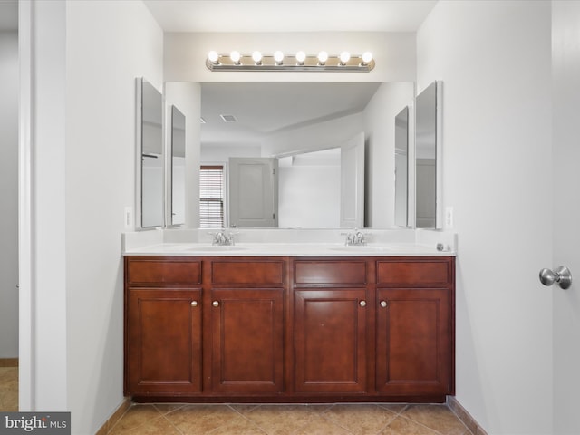 bathroom with double vanity, a sink, and baseboards