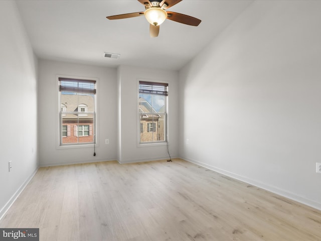 empty room featuring visible vents, ceiling fan, baseboards, and wood finished floors