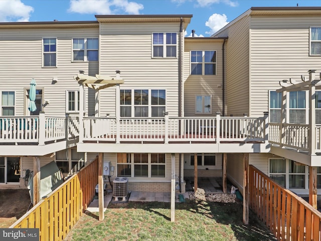 back of property with cooling unit, fence, a wooden deck, and a pergola