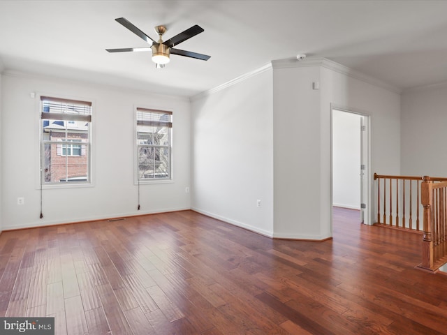 spare room featuring baseboards, crown molding, a ceiling fan, and wood finished floors