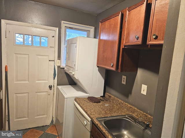 laundry area with laundry area, stacked washer and dryer, and a sink