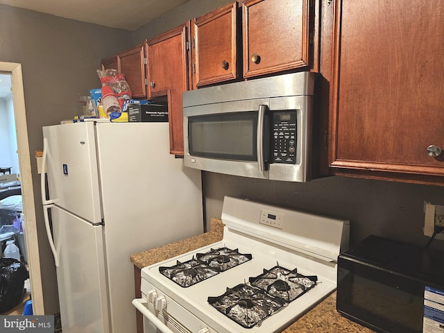 kitchen featuring white appliances and brown cabinetry