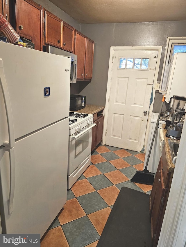 kitchen featuring white appliances and brown cabinets