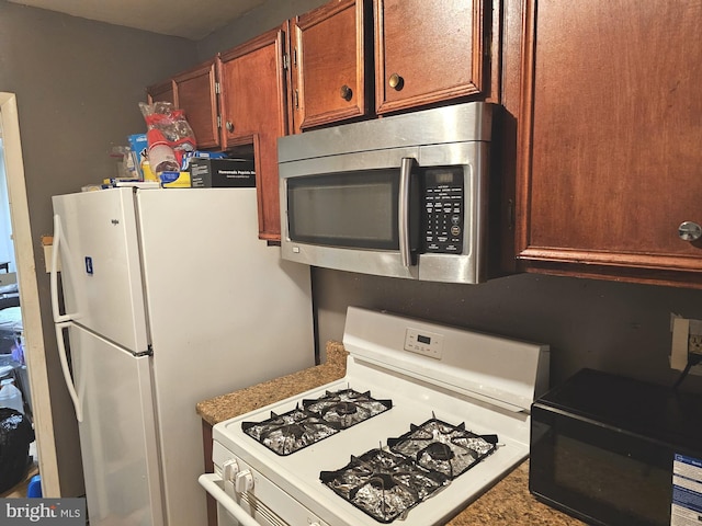 kitchen with white appliances and brown cabinetry