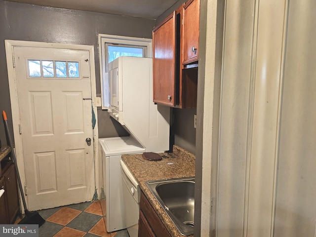 washroom featuring a sink and stacked washer / drying machine