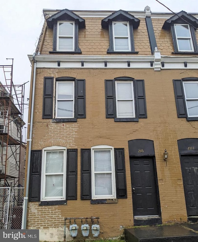 second empire-style home with mansard roof and brick siding