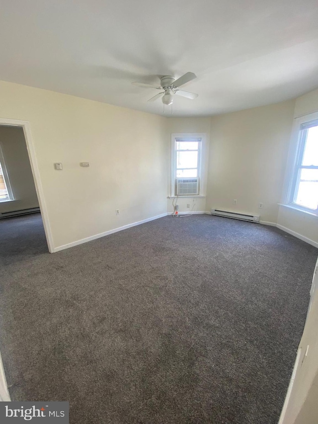 empty room with a wealth of natural light, a baseboard radiator, dark carpet, and baseboards