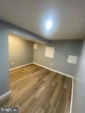 finished basement featuring dark wood-style flooring and baseboards