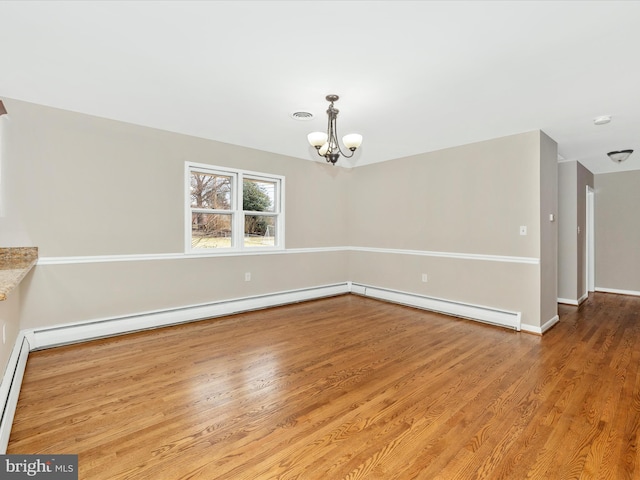 unfurnished dining area featuring baseboard heating, a notable chandelier, baseboards, and wood finished floors