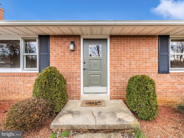 doorway to property featuring brick siding