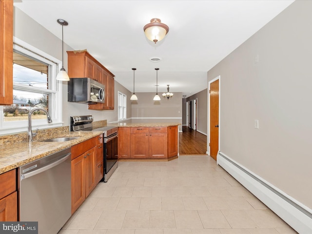 kitchen featuring a baseboard radiator, a peninsula, a sink, appliances with stainless steel finishes, and brown cabinets