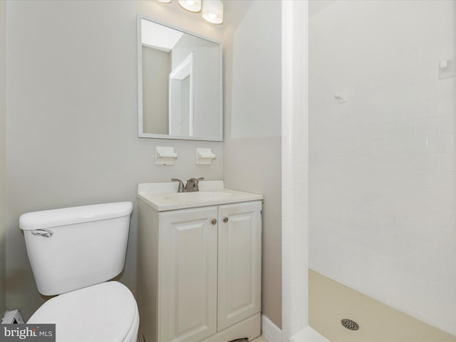 bathroom featuring tiled shower, vanity, and toilet