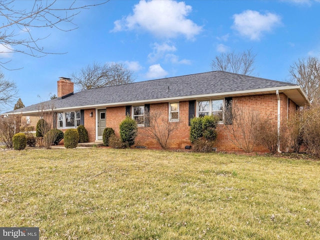 ranch-style home with a front yard, brick siding, a chimney, and roof with shingles