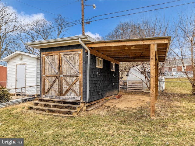 view of shed featuring an attached carport and fence