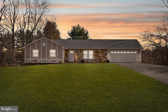 view of front facade with driveway, a front lawn, and an attached garage