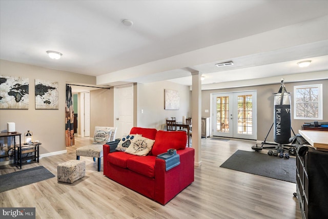 living area featuring french doors, visible vents, baseboards, and wood finished floors