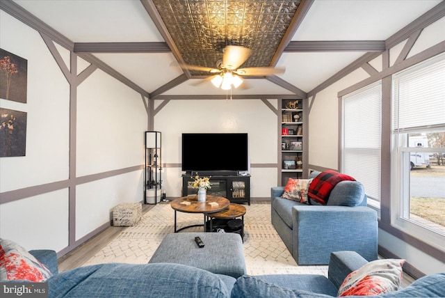 living area featuring built in features, crown molding, baseboards, and wood finished floors