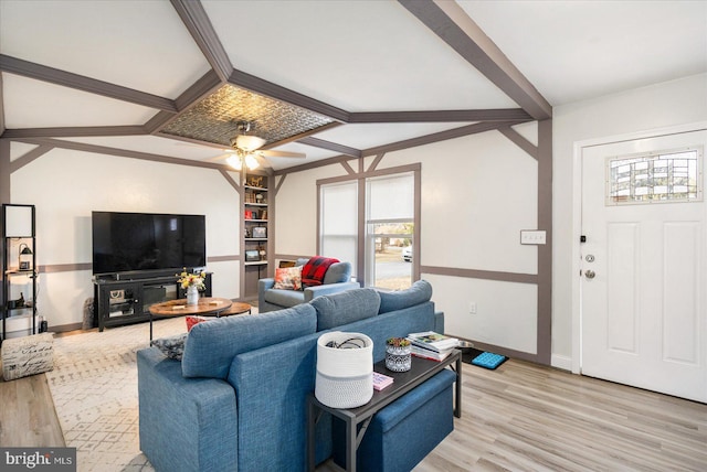 living area with built in features, light wood-type flooring, beam ceiling, and baseboards