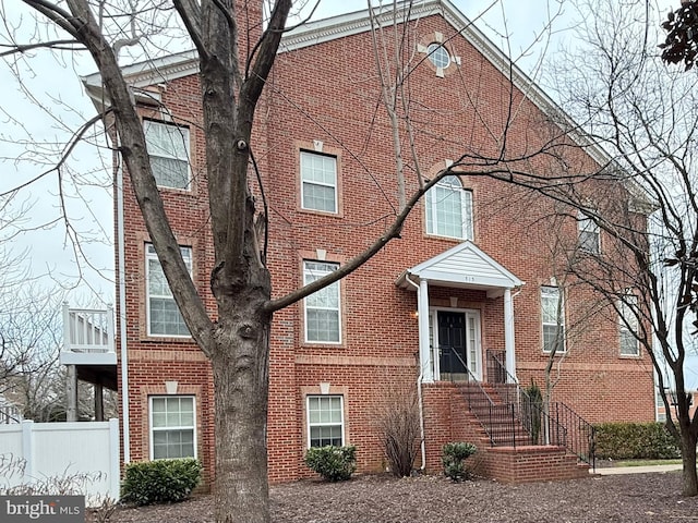 view of front of property with brick siding and fence