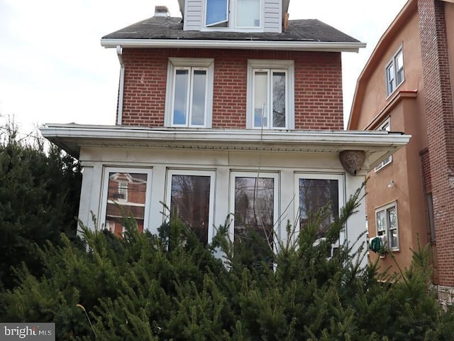 rear view of property with brick siding