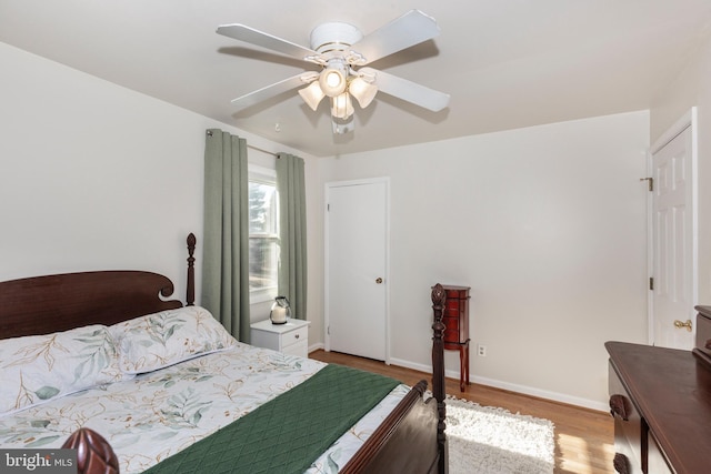 bedroom with a ceiling fan, baseboards, and wood finished floors